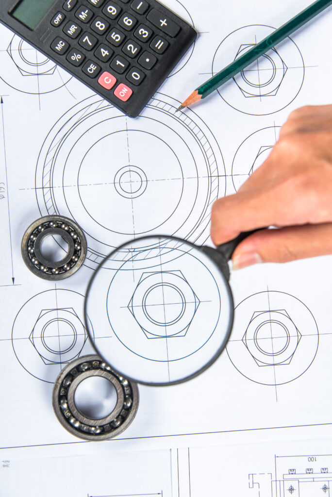 Dłoń trzymająca lupę nad dokumentami 