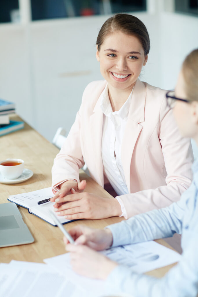 Młoda kobieta rozmawiająca ze swoim współpracownikiem